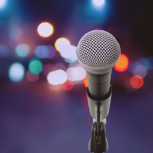 Symbolbild fuer Gesangsangebote im Kreativ-Haus zeigt Micro vor buntem Buehnenlicht