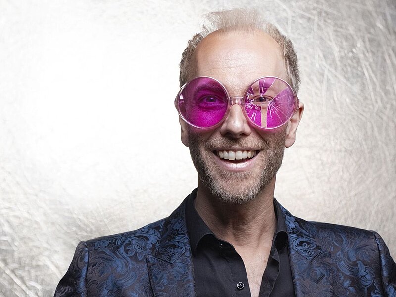 Künstler Michael Krebs trägt eine rosa Brille