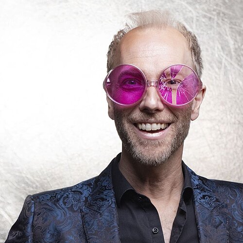 Künstler Michael Krebs trägt eine rosa Brille