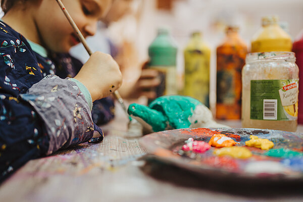 Kind mald mit Pinsel im Kreativ-Haus