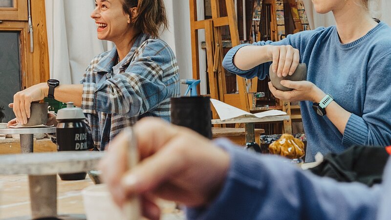 Einblick Töpferkurs, Teilnehmende formen mit Ton am Werktisch