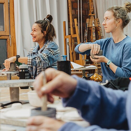 Einblick Töpferkurs, Teilnehmende formen mit Ton am Werktisch