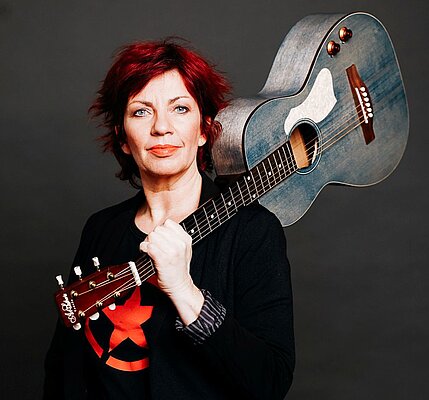 Dagmar Schoenleber mit Gitarre auf der Schulter getragen