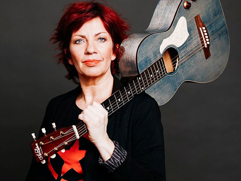 Dagmar Schoenleber mit Gitarre auf der Schulter getragen