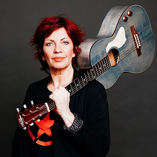 Dagmar Schoenleber mit Gitarre auf der Schulter getragen