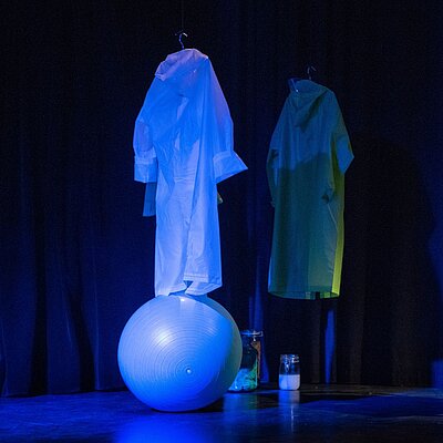 Zwei Regenmäntel und ein Sitzball im Raum