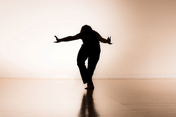 Tänzerin im Gegenlicht im Tanzsaal im Kreativ-Haus