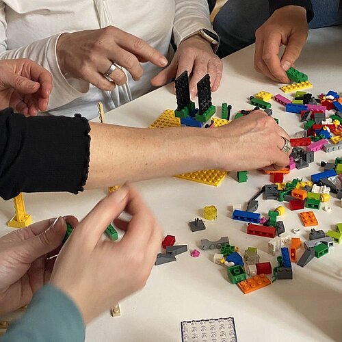 Hände arbeiten mit Lego