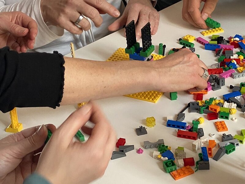 Hände arbeiten mit Lego